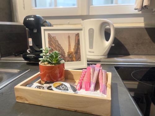 une photo et une plante dans un plateau en bois sur un comptoir de cuisine dans l'établissement Le Cocon du Panthéon, à Paris