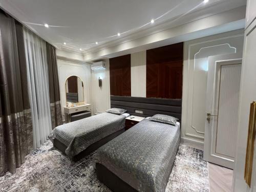 a hotel room with two beds and a mirror at Guest House Uzbegim in Tashkent