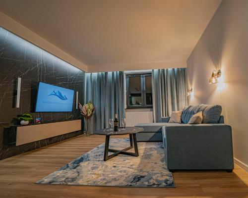 a living room with a couch and a tv at Apartament w Cieplicach Prime in Jelenia Góra