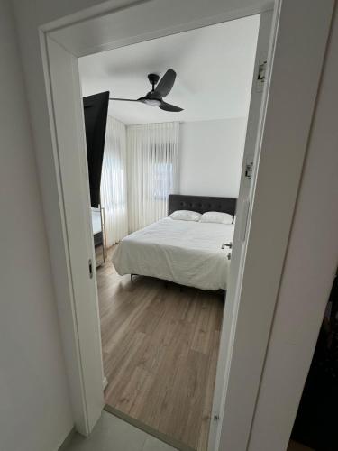 a bedroom with a bed and a ceiling fan at דירת נופש ירושלים תלפיות in Geʼullim