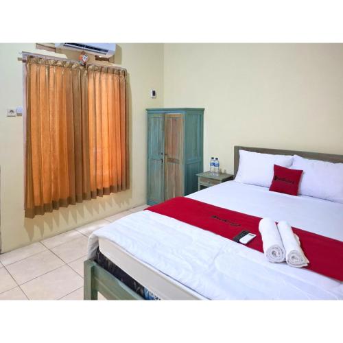 a bedroom with a large bed with two towels on it at RedDoorz near Alun Alun Jepara in Kesembu