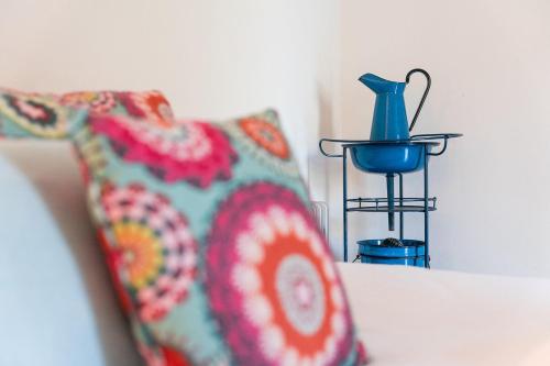 a pillow and a blue vase sitting on a bed at GuestReady - Quintinha casas do jardim 2 in Arcos de Valdevez