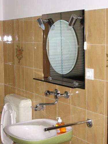 a bathroom with a mirror and a sink at Guest House Rože in Ilirska Bistrica