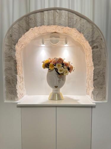 a vase with flowers sitting on top of a shelf at Forno Mongelli 2.0 in Putignano