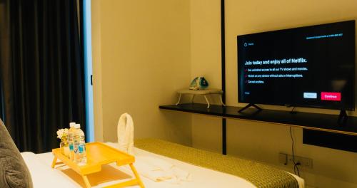 a room with a tv and a bed with a table at Axon Residence KLCC - KL HOME in Kuala Lumpur
