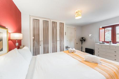 a bedroom with a large white bed and red walls at GuestReady - Quintinha casas do jardim 2 in Arcos de Valdevez