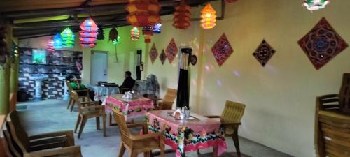 a restaurant with tables and chairs and colorful lights at Bhitarkanika Eco Resort TENT in Righāgarh