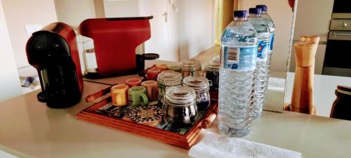 a tray with bottles of water and other items on a counter at Casa do Mocho Private Room in Lisbon in Paço de Arcos