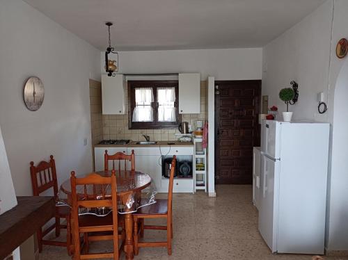 Una cocina y un comedor con una mesa y un refrigerador. en Spanien Bungalow, en Teulada