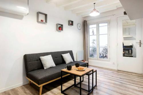 un salon avec un canapé et une table dans l'établissement GuestReady - Central Apt in Paris, à Paris