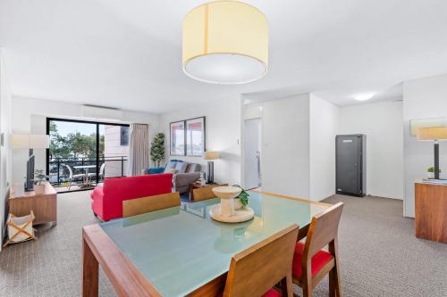 a living room with a table and a couch at Hay Street CBD Apartment close to Swan River in Perth
