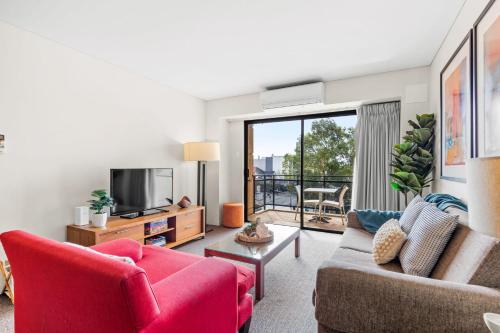 a living room with a couch and a tv at Hay Street CBD Apartment close to Swan River in Perth