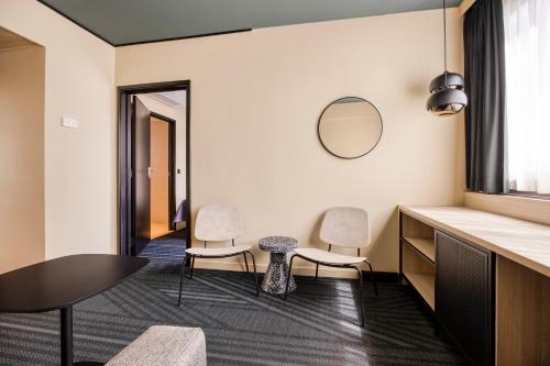 a room with two chairs and a table and a mirror at Citybox Brussels in Brussels
