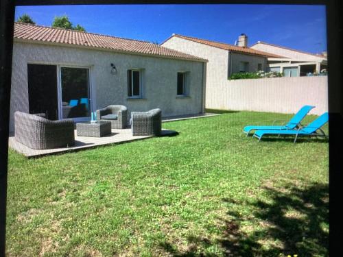 une cour avec deux chaises de jardin et un patio dans l'établissement Maison, à Saint-Hilaire-de-Talmont