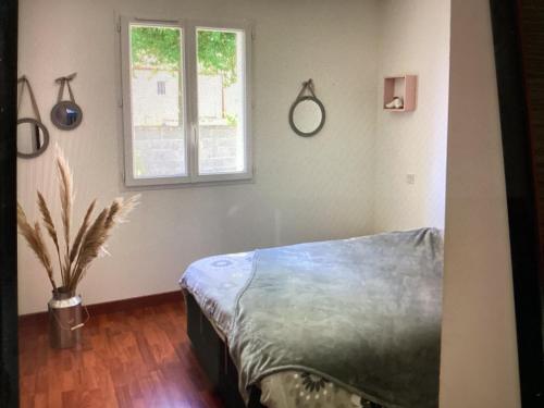une chambre avec un lit, une fenêtre et un vase dans l'établissement Maison, à Saint-Hilaire-de-Talmont