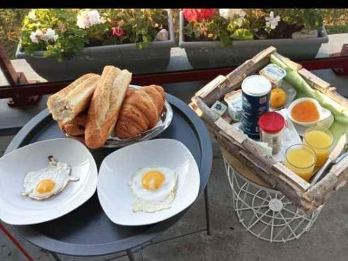 - une table avec des œufs, du pain et un panier de pain grillé dans l'établissement La villa DEF'S, à Huppy