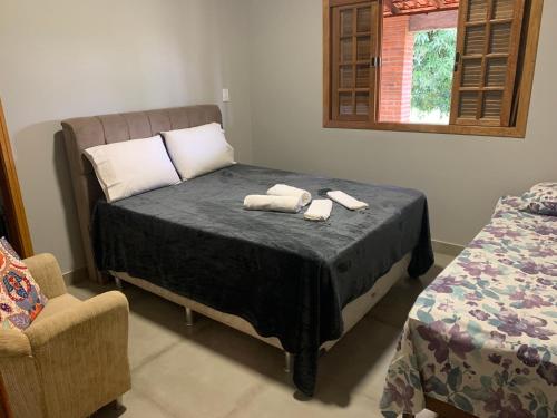 a bedroom with a bed with two towels on it at Chácara Primavera in Capão Bonito