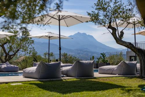 a patio with pillows and umbrellas with a view of mountains at Casa Plenilia in Pianella