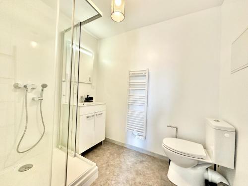 une salle de bain blanche avec toilettes et douche dans l'établissement Le Cuivre proche de la gare, à Limoges