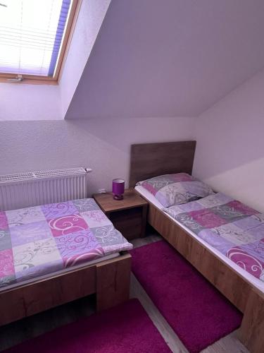 two twin beds in a room with a purple rug at Ubytovanie v súkromí Horec in Liptovský Mikuláš