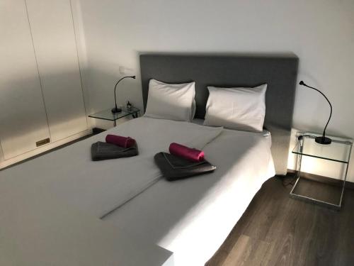 a large white bed with two red pillows on it at baleal penthouse in Ferrel