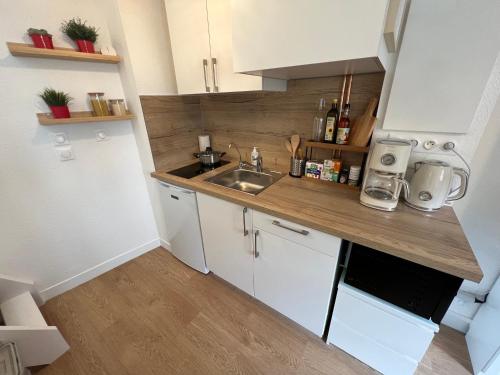 une petite cuisine avec des armoires blanches et un évier dans l'établissement Duplex Cosy / Terrasse / Cour Intérieure, à Rennes