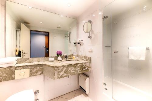 a bathroom with a sink and a mirror at Crowne Plaza Frankfurt Congress Hotel by IHG in Frankfurt/Main