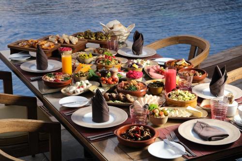 a table full of food on a table near the water at Voco - Riyadh by IHG in Riyadh