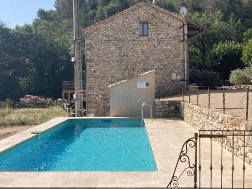 basen przed kamiennym budynkiem w obiekcie Petite Maison en Provence w mieście Plaisians