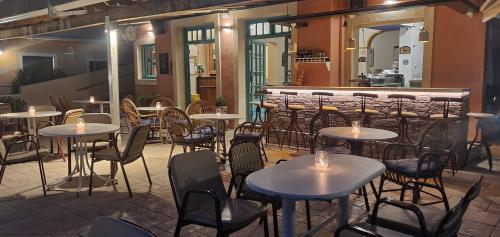 a restaurant with tables and chairs and a bar at Paleo Inn Hotel in Paleokastritsa
