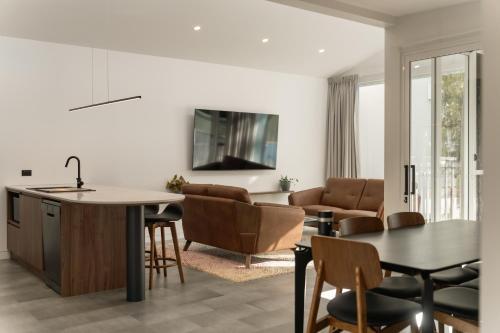 a kitchen and living room with a table and chairs at Clare Hillside Apartments in Clare
