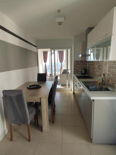 a kitchen and dining room with a table and chairs at Skopje Sky Apartments & Floor 33th 28th & 25th & 19th & 13th 12th With Pool & Spa & Fitness & Parking Included in Price in Skopje