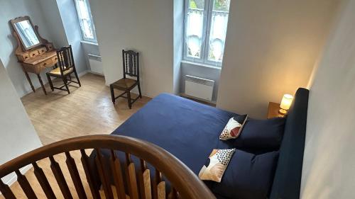 un salon avec un canapé bleu et une télévision dans l'établissement Gîte au cœur de la ville ancienne, à Terrasson