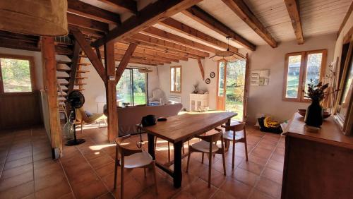 une salle à manger avec une table et des chaises en bois dans l'établissement Gite du Mouliot, à Castets