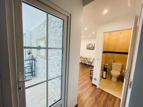 a bathroom with a toilet and a door to a room at Maison Familiale avec Jardin in Ozoir-la-Ferrière