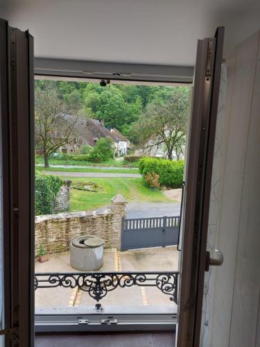 an open window with a view of a yard at Votre gîte au Domaine du Lynx in Baume-les-Messieurs