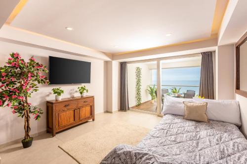 a living room with a couch and a tv at Serene Beachfront Escape Includes Delicious Breakfast in Puerto Vallarta