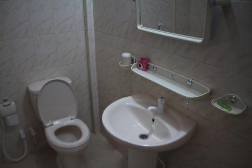 a bathroom with a white toilet and a sink at Guillet Beach Home in Matara