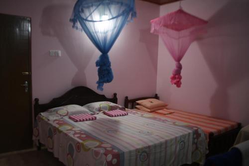 a childs bedroom with a bed with pink walls at Guillet Beach Home in Matara