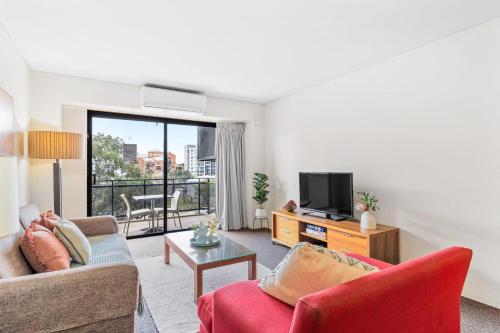 a living room with two couches and a tv at Apartment with City Views in East Perth in Perth