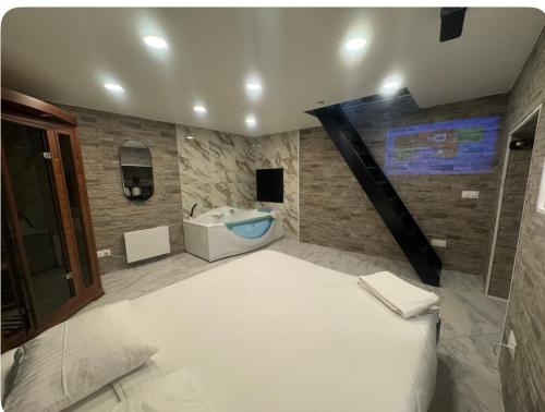 Un dormitorio con una cama grande y una bañera. en Maison Appartement Triplex avec jacuzzi et sauna, en Saint-Étienne