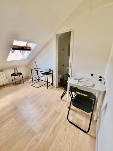 une chambre avec une table, des chaises et une lucarne dans l'établissement Le Paris Thabor Centre-ville, à Rennes