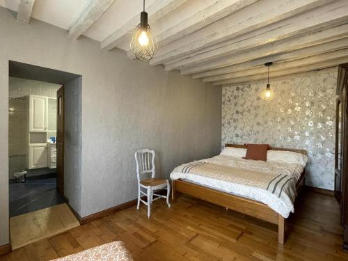 une chambre avec un lit et une chaise dedans dans l'établissement Armanaga, à Ainharp