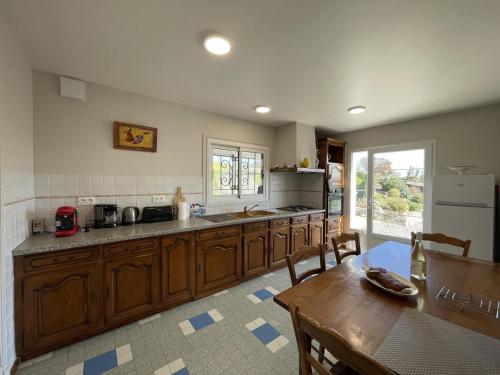 d'une cuisine avec des placards en bois, une table et un sidx de table. dans l'établissement Armanaga, à Ainharp