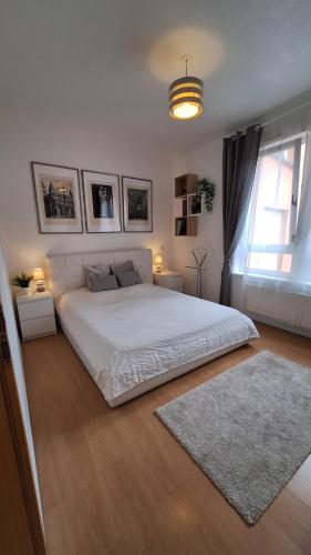 Appartement design et loisirs proche Saverne في Dettwiller: غرفة نوم بيضاء مع سرير كبير ونافذة