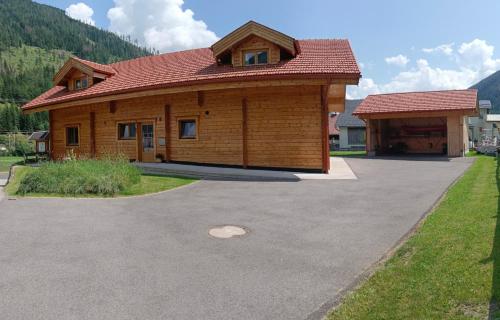 a wooden house with a red roof and a driveway at Houghton Haus in Mallnitz