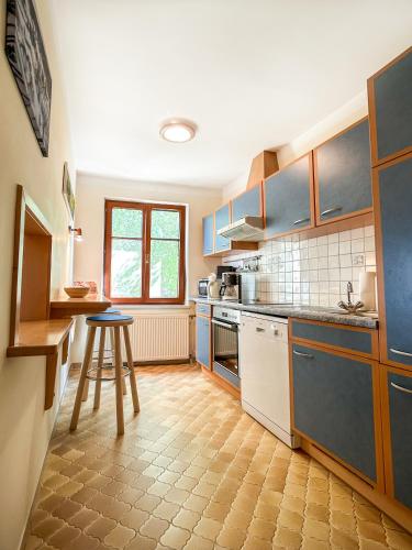 a kitchen with blue cabinets and a table in it at Apartments Haus Morgensonne in Reidling