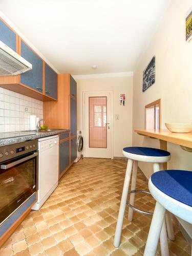 a kitchen with blue cabinets and a table and stool at Apartments Haus Morgensonne in Reidling
