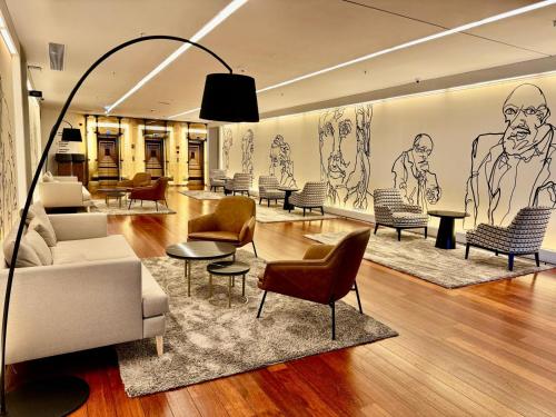 a living room with chairs and a couch and tables at Holiday Inn Porto Gaia by IHG in Vila Nova de Gaia