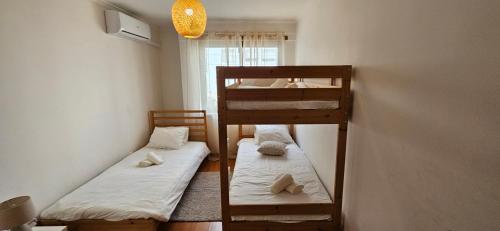 two bunk beds in a room with a window at Modern 3 Bed Flat - Beaches, Expo & City Fun - Your Gateway to Lisbon in Montijo